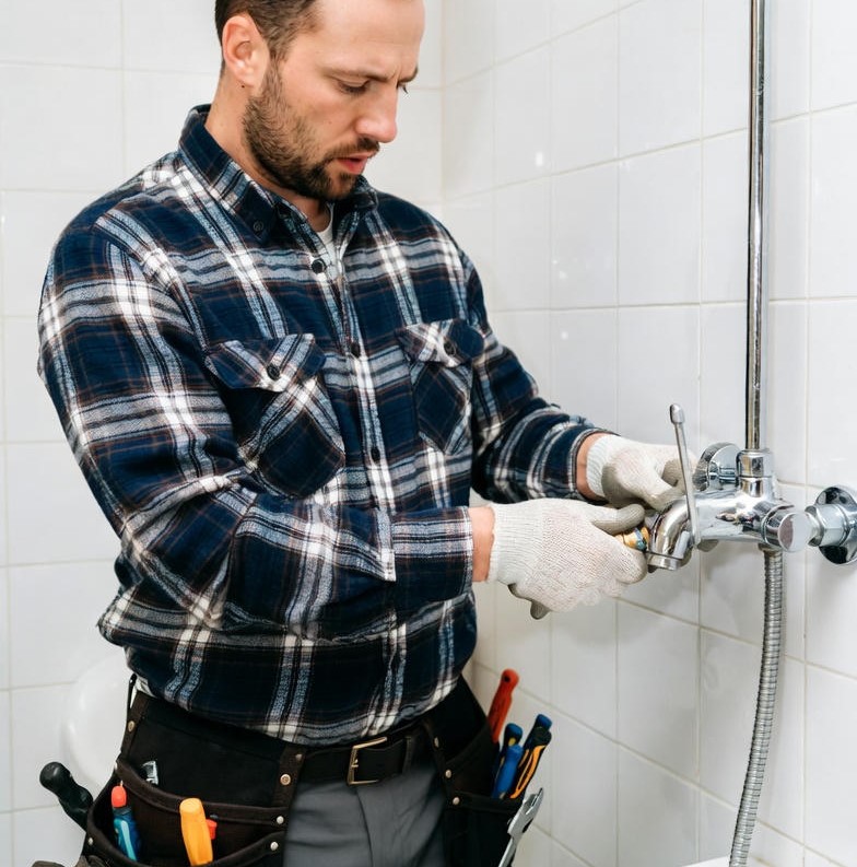 Marido de aluguel da empresa Junior Piccin realizando reparo de vazamento no banheiro